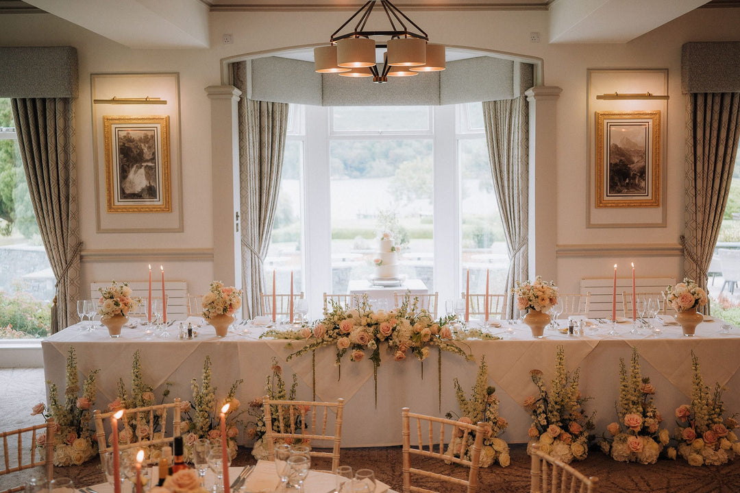 Wedding reception room with multiple tables styled with elegant taper candles