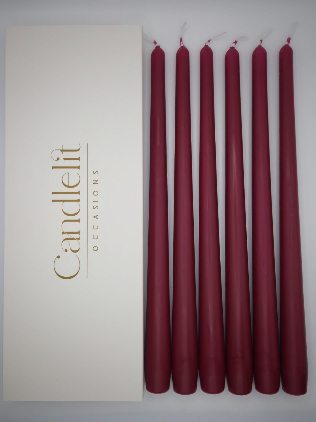 Burgundy red taper candles styled for luxury wedding tablescape